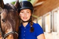 Beautiful jockey girl with her purebred bay horse Royalty Free Stock Photo