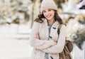 Beautiful joyful woman autumn portrait. Smiling student girl wearing warm clothes and hat in a city in winter Royalty Free Stock Photo