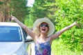 Beautiful joyful woman in front of a white car with a key in her hand on a summer sunny day against the backdrop of green trees Royalty Free Stock Photo