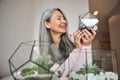 Beautiful joyful woman holding geometric glass succulent terrarium Royalty Free Stock Photo