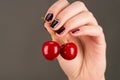 Beautiful juicy cherry in female hand with luxurious manicure Royalty Free Stock Photo