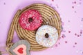 Beautiful juicy donuts with sweet plates on a decorative tray. Cupcake on a pink background with colorful hearts for kitchen