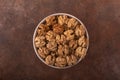 Beautiful kernels of peeled walnuts in a light bowl on a vintage rusty background. Royalty Free Stock Photo