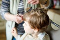 Beautiful kid boy with blond hairs getting his first haircut. Royalty Free Stock Photo