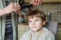 Beautiful kid boy with blond hairs getting his first haircut. Royalty Free Stock Photo