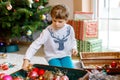 Beautiful kid boy and colorful vintage xmas toys and balls. Child decorating Christmas tree Royalty Free Stock Photo