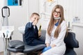 Beautiful kid boy smiling in dentist`s chair and showing thumbs up gestures of good class Royalty Free Stock Photo