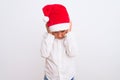 Beautiful kid boy wearing Christmas Santa hat standing over isolated white background with hand on head for pain in head because Royalty Free Stock Photo