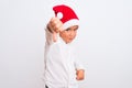 Beautiful kid boy wearing Christmas Santa hat standing over isolated white background looking unhappy and angry showing rejection Royalty Free Stock Photo