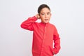 Beautiful kid boy wearing elegant red shirt standing over isolated white background smiling doing phone gesture with hand and Royalty Free Stock Photo