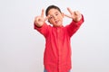 Beautiful kid boy wearing elegant red shirt standing over isolated white background smiling looking to the camera showing fingers Royalty Free Stock Photo