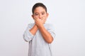 Beautiful kid boy wearing grey casual t-shirt standing over isolated white background shocked covering mouth with hands for