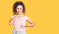 Beautiful kid girl with curly hair wearing casual clothes gesturing with hands showing big and large size sign, measure symbol Royalty Free Stock Photo