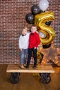 Beautiful kids, little boys celebrating birthday and blowing candles on homemade baked cake, indoor. Birthday party for Royalty Free Stock Photo