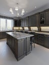 Beautiful kitchen in luxury home with island, pendant lights, cabinets, and self-leveling floors. marble backsplash, elegant