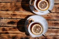 Beautiful kitchen set for a tea ceremony for two people. Two white ceramic tea cups on saucers on a wooden table. Black tea with Royalty Free Stock Photo