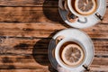 Beautiful kitchen set for a tea ceremony for two people. Two white ceramic tea cups on saucers on a wooden table. Black tea with Royalty Free Stock Photo