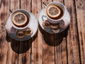 Beautiful kitchen set for a tea ceremony for two people. Two white ceramic tea cups on saucers on a wooden table. Black tea with Royalty Free Stock Photo