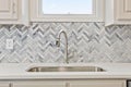 Beautiful kitchen sink with a silver faucet and tiled walls