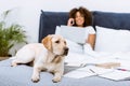 beautiful labrador dog lying on bed while woman