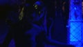 Beautiful ladies dancing and embracing behind metal chain fence in nightclub