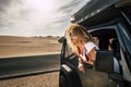 Beautiful lady caucasian people female enjoy th ewind in the outdoor nature out of her black car - desert outdoor around and Royalty Free Stock Photo