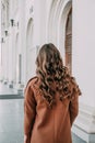 The beautiful lady with curly hair. The back view of a girl. Woman walking down the street. Traveler, summer fashion trend Royalty Free Stock Photo