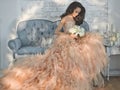 Beautiful lady in gorgeous couture dress on sofa Royalty Free Stock Photo