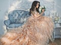 Beautiful lady in gorgeous couture dress on sofa