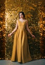 Beautiful lady model posing retro elegant woman.luxury long evening golden dress