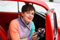 Beautiful lady sitting in car with camera. Female photographer. Travelling concept Royalty Free Stock Photo