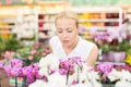 Beautiful lady smelling colorful blooming orchids.