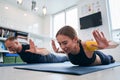 Beautiful lady in sportswear with yellow tape on shoulder practicing locust yoga pose