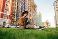 Beautiful lady in stylish vintage clothing is resting with a pet on the lawn, petting a dog on a walk. Pretty girl sitting on Royalty Free Stock Photo