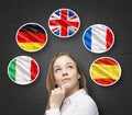 Beautiful lady is surrounded by bubbles with european countries' flags (Italian, German, Great Britain, French, Spanish). Learning Royalty Free Stock Photo