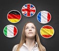 Beautiful lady is surrounded by bubbles with european countries' flags (Italian, German, Great Britain, French, Spanish). Learning Royalty Free Stock Photo