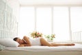 Beautiful lady wearing white underwear lying on white bed with h Royalty Free Stock Photo