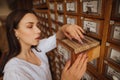 Beautiful lady in a white blouse looking for books in the archives of the old library, opened a drawer with information Royalty Free Stock Photo