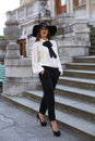 Beautiful ladylike woman wearing elegant clothes,posing at park