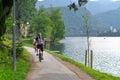 Beautiful Lake Bled in the Julian Alps and cycling tourist. Mountains, clear aquamarine water lake and dramatic blue sky
