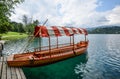 Beautiful Lake Bled in the Julian Alps and old wooden boat. Mountains, clear aquamarine water, tourist boat, lake and dramatic