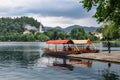 Beautiful Lake Bled in the Julian Alps and two old wooden boats. Mountains, clear aquamarine water, tourist boat, lake and