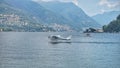 A seaplane takes off from the water on Lake Como. Royalty Free Stock Photo