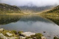 Beautiful lake from the group of Spronser Lakes surrounded by big mountains covered in fog