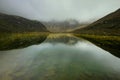 Beautiful lake from the group of Spronser Lakes surrounded by big mountains covered in fog