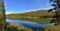 Beautiful lake high in the mountains surrounded by forest. Blue sky, white clouds. Royalty Free Stock Photo