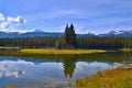 Beautiful lake high in the mountains surrounded by forest. Blue sky, white clouds. Royalty Free Stock Photo