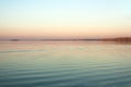 Beautiful lake landscape, and sunset. Blue waves and horizon line on water. Beautiful background Royalty Free Stock Photo