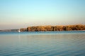 Beautiful lake landscape, yacht, and sunset. Blue waves, boat and horizon line on water. Beautiful background Royalty Free Stock Photo