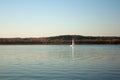 Beautiful lake landscape, yacht, and sunset. Blue waves, boat and horizon line on water. Beautiful background Royalty Free Stock Photo